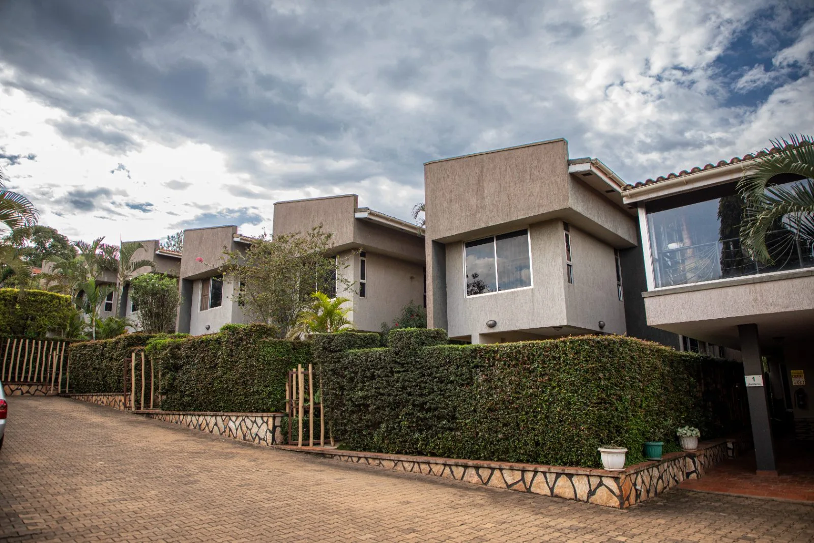 A row of The Pearl Cottages serviced apartments framed by manicured hedges and gardens in Kiwatule, Kampala