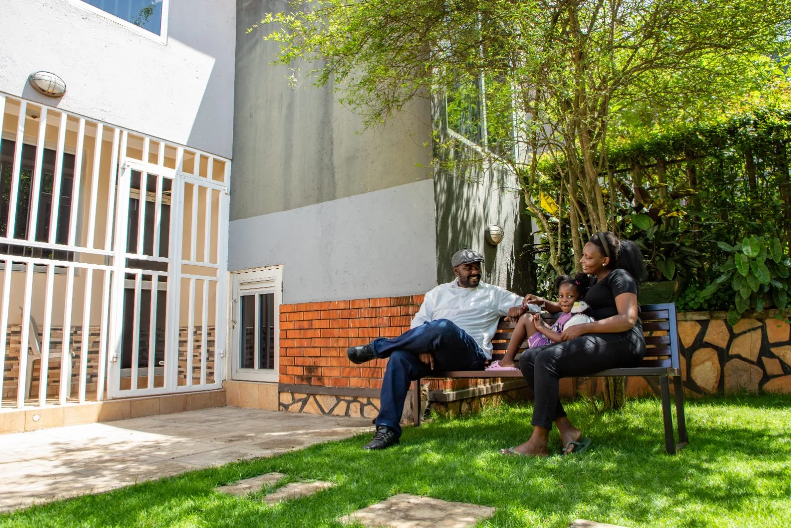 Guests relaxing on a bench in the private garden surrounded by greenery