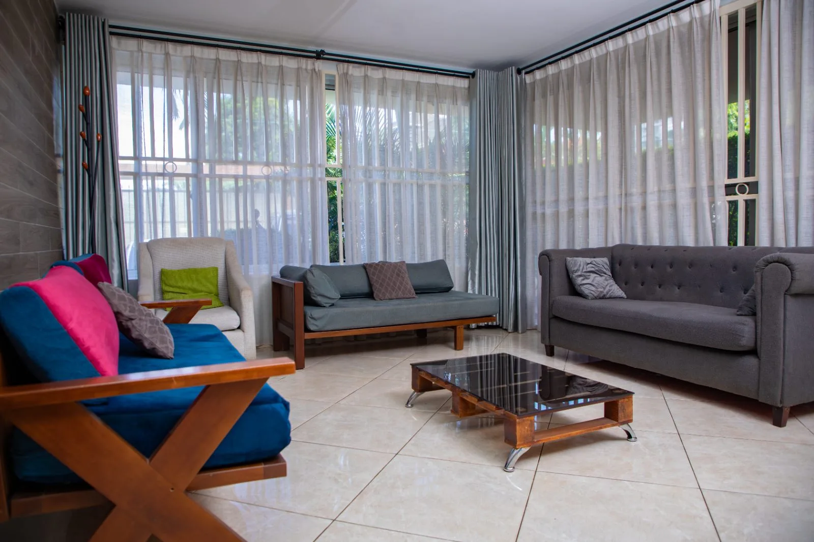 Bright living room with sofas, colourful cushions and a glass coffee table
