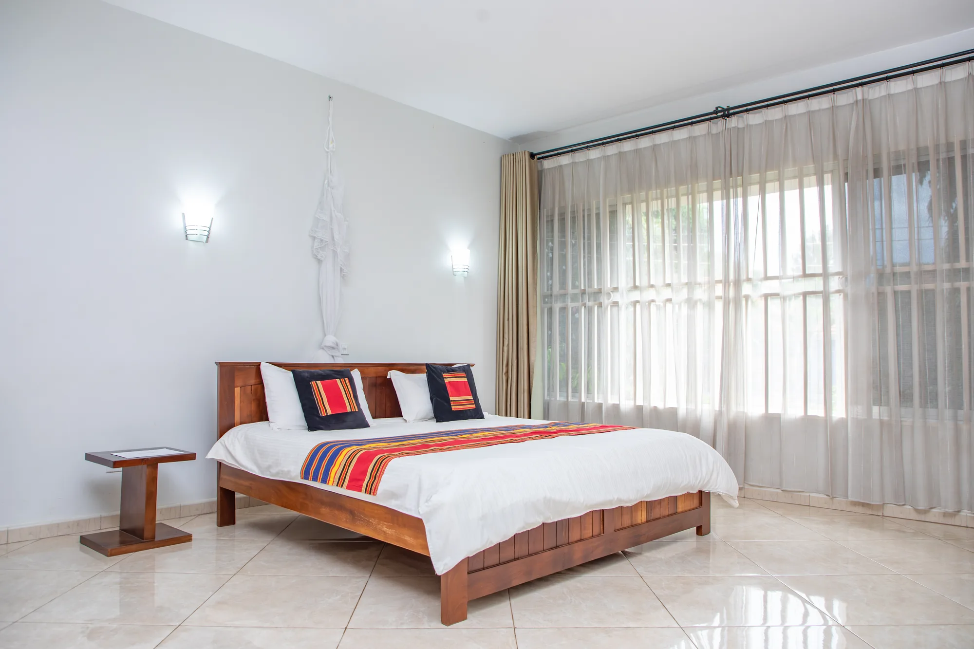 The Lily two-bedroom master bedroom with soft natural light through sheer curtains