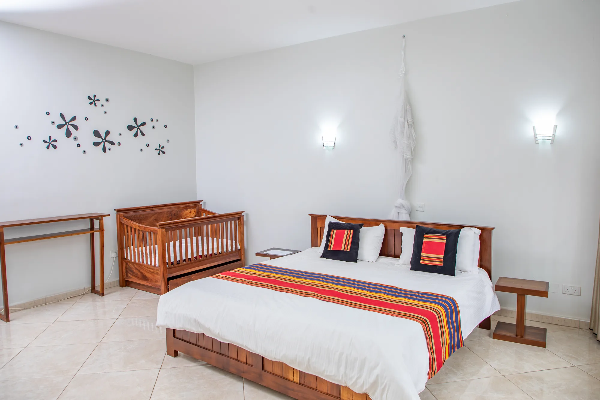 The Gardenia three-bedroom apartment's spacious master bedroom with a king bed and cot